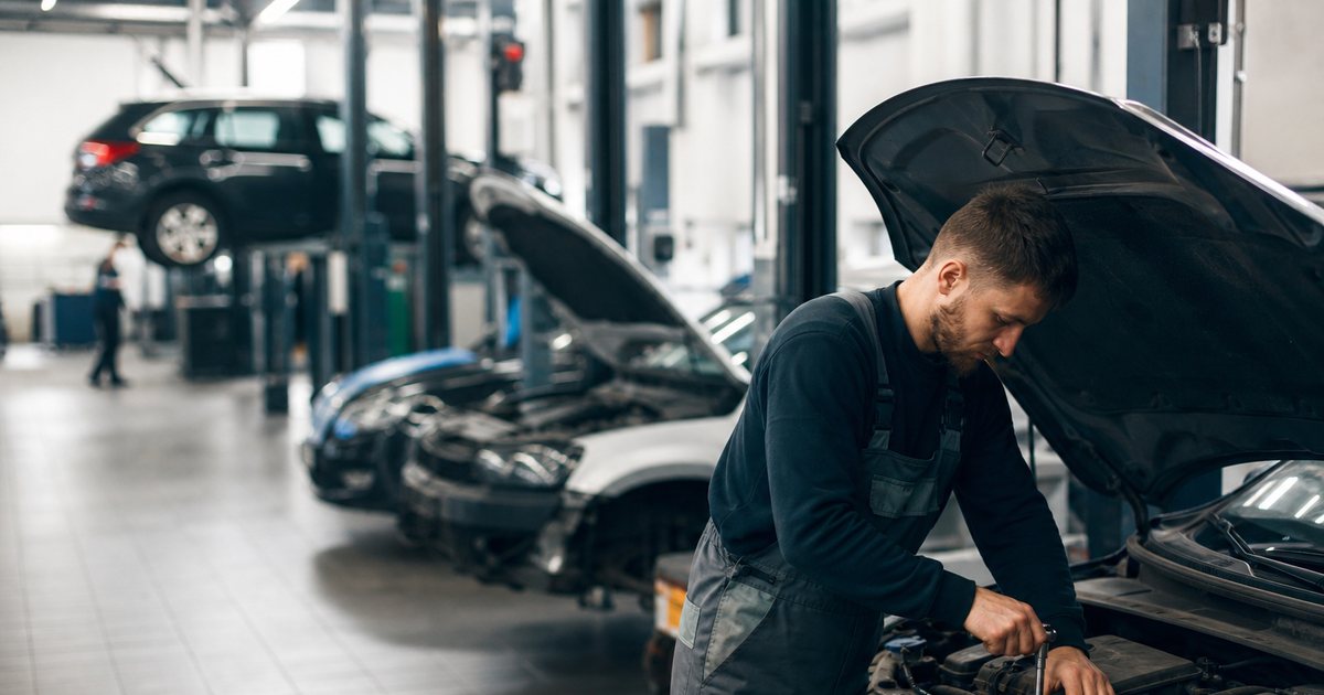 An organized auto repair shop with cars parked in labeled work bays
